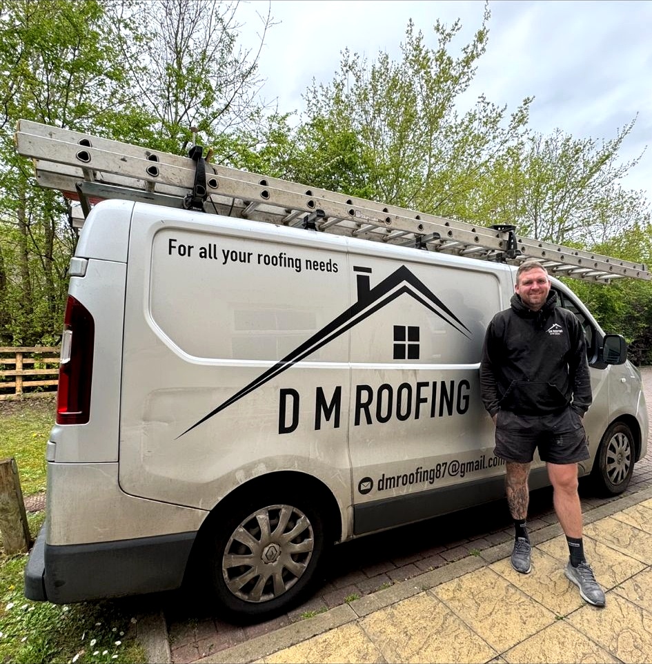 DM Roofing owner standing next to his branded company van — professional local roofer