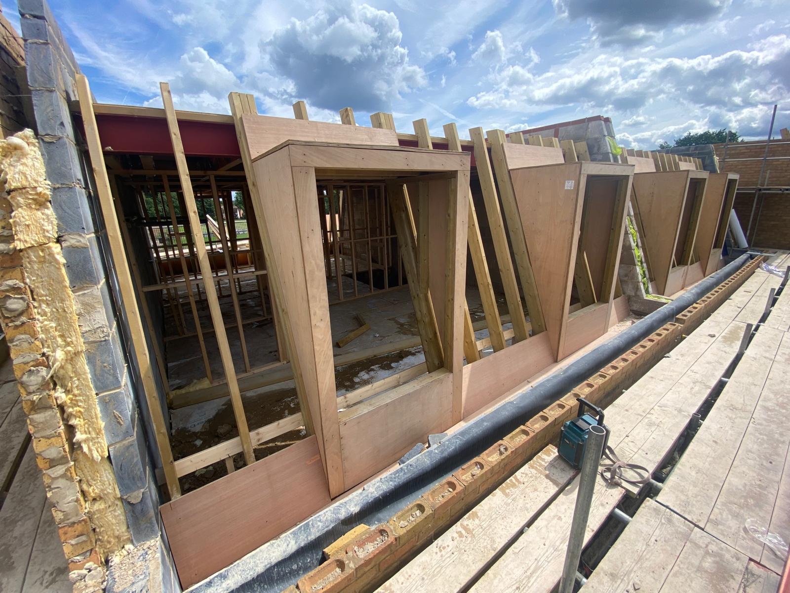 DM Roofing — mansard roof dormer timber frame construction, plywood dormer boxes being built on new residential development