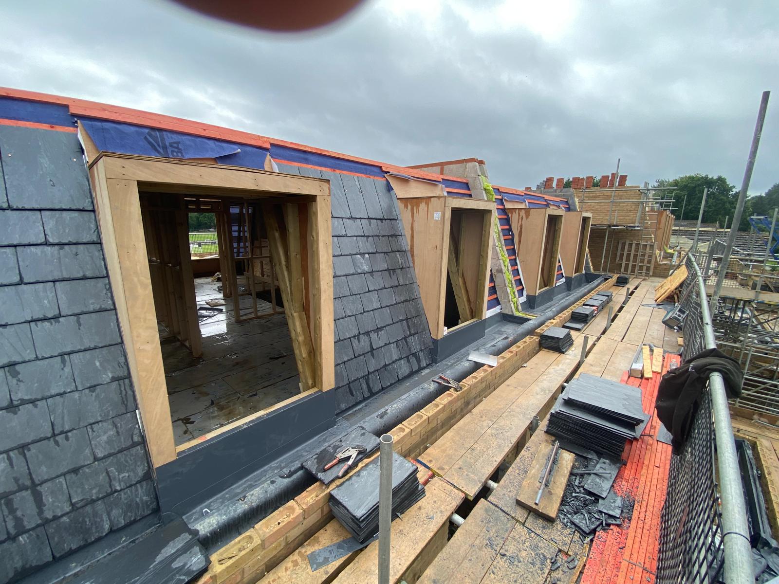 DM Roofing — natural slate being laid on mansard roof dormer cheeks and faces, lead flashing installation in progress